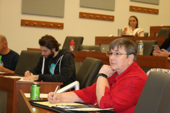 Students sit and take notes in a college auditorium.