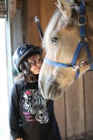 Girl standing by horse