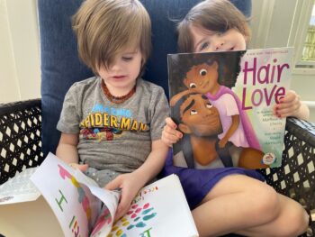 Two children read and show off their books.