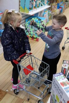 Two children play in the toy store. 