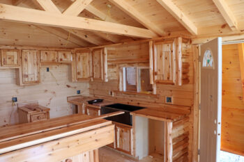 The inside of the cabins is all light colored wood except for a black sink. 