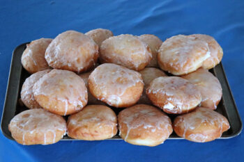 Fresh, golden donuts covered with a white glaze.