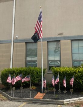 The American and POW-MIA flags outside the coliseum. They are surrounded by smaller American flags. 