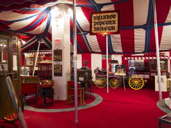 A stained glass sign stating Wyandot Popcorn Museum is surrounded by exhibits. 