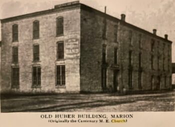 A photo of the three-story brick huber building with windows.