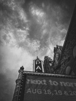 A black and white picture of the Plaace names in lights above the modern lighted marquee.