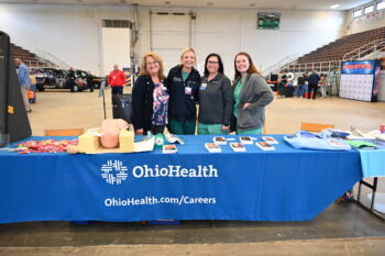 Ohio health employees stand behind their booth.