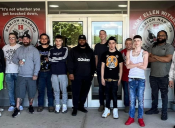 A group of barbers and students smile. 