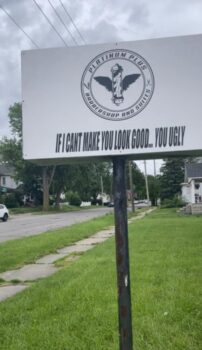 White sign with black lettering and slogan