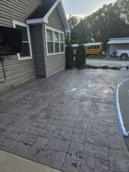 Concrete that looks like pavers forms a patio outside of a home.