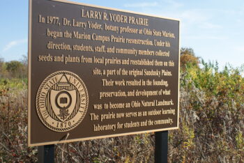 A historical sign explains Dr. Yoder's impact on creating the prairie.