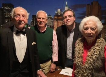 Three men and one woman smile.