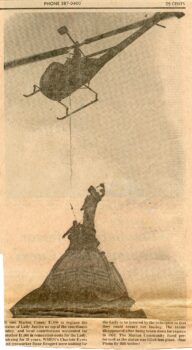 Newspaper clipping of a helicopter lowering the statue onto the dome.