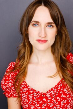 A woman with blue eyes and long brown hair. 