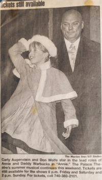 A black-and-white clipping of Carly as a child dressed as Annie next to the actor playing Daddy Warbucks from the Marion Star. 