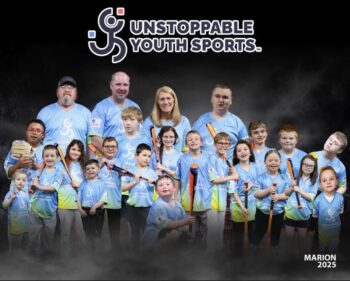 The Unstoppable coaches pose with children and teens in uniforms holding bats and baseball gloves.