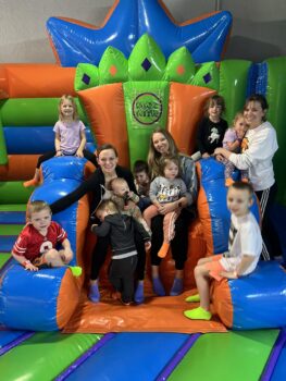 women and childrensmile on a large bouncy throne at MaxAiir Inflatapark.