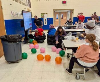 Children play a game with ballons .