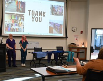 The owner and a young woman in scrubs present at the Forge competition.